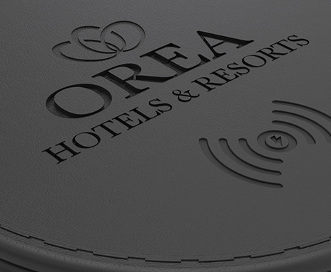 vyražené logo OREA na černé kuži qi nabíječky